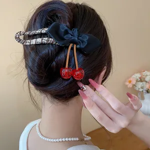 Detailed shot of bow hair clip with resin cherry pendants in a chic hairstyle