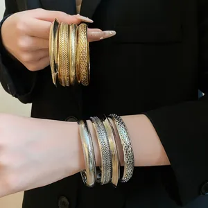Primo piano di larghi bracciali in metallo vintage con varie finiture strutturate