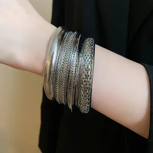 Primo piano di bracciali rigidi in metallo argento con texture e design a rete