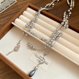 Detailed view of elegant silver-grey pearl necklace featuring crystal flower pendants