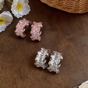 Elegant pleated C-shaped stud earrings featuring pink enamel and sparkling zircons stones.