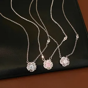 Detail of silver-toned flower pendant necklaces featuring pink and white sparkling zirconia