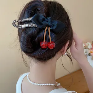 Detailed view of an elegant fabric bow hair clip featuring cute resin cherry charms