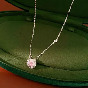 Detailed view of rotatable flower pendant necklace with a sparkling pink zircon