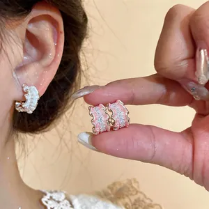 Elegant C-shaped ruffled earrings with pink enamel and sparkling cubic zirconia.