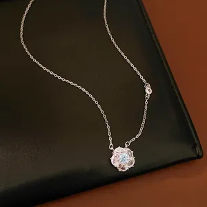 Detailed view of a rotating flower pendant necklace with shimmering zircon stones.