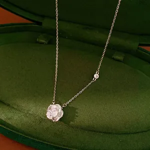 Detail shot of a sparkling zirconia flower pendant necklace in a green velvet box