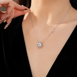 Detailed view of silver flower rotatable necklace with blue zircon on female model neck