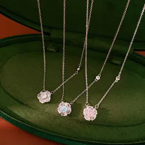 Detail view of dainty rotating flower necklaces featuring blue, pink and clear zirconia