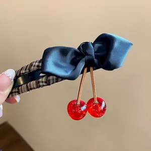 Detailed view of elegant black bow hair clip with dangling red resin cherries
