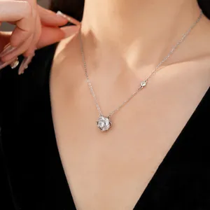 Detailed view of a silver rotating flower necklace with zircon on a model's neck