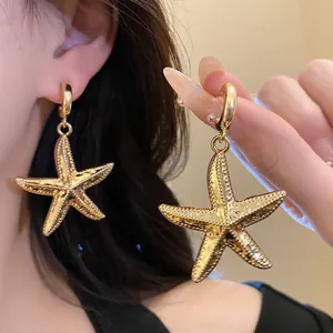 Detailed view of vintage gold starfish drop earrings with intricate textured finish