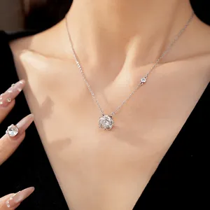Detail view of an elegant rotating flower pendant necklace with zircon inlay on a model.