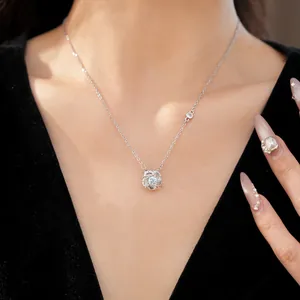 Detailed close-up of an elegant rotating flower pendant necklace with shimmering zircons
