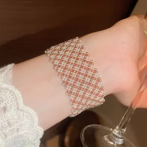 Vista dettagliata di un ampio bracciale magnetico in perle di vetro con motivo a scacchi.