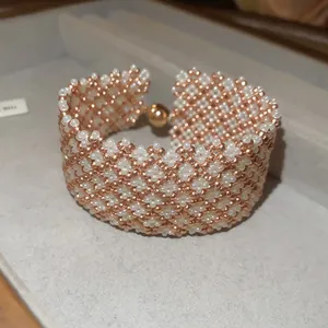 Dettaglio macro di bracciale artigianale di perle con chiusura magnetica e tocchi oro rosa