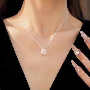Elegant close-up of a silver rotating flower pendant necklace with a pink zircon stone