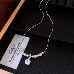 Detail view of a vintage square zircon pendant necklace featuring elegant white pearls