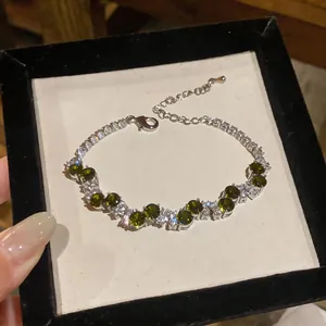 Detailed close-up of a vintage style bracelet with dark green and clear stones in silver