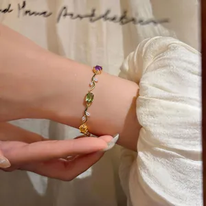 Elegant vintage French style gold bracelet with colorful oval zircons worn on a lady's wrist