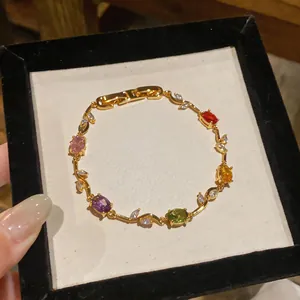 Detail view of gold-tone bracelet with colorful oval zircons and marquise accents