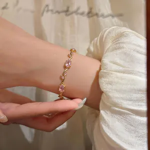 Detailed close-up of a French vintage gold bracelet with pink oval zircons on wrist