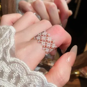 Primo piano dettagliato che mostra l'intricata trama di un anello in perline di vetro bianco e oro