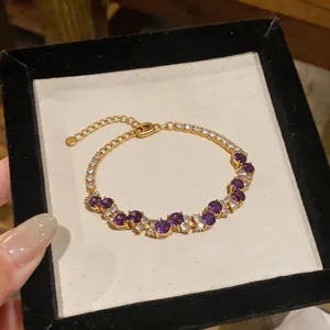 Detail view of gold zircon bracelet with purple stones and adjustable chain extension