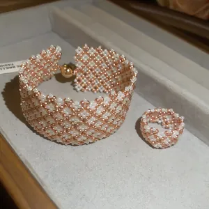 Primo piano del set bracciale e anello in perline intrecciate con texture oro rosa