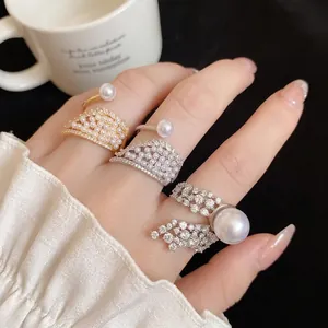 Elegant zircon wing and pearl open rings in gold and silver finish worn on hand