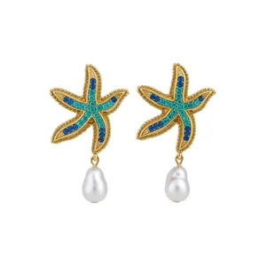 Gold starfish stud earrings with blue crystals and teardrop pearl charms.