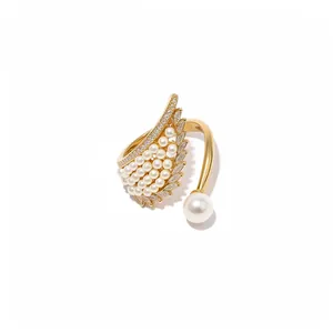 Elegant gold wing-shaped open ring with small pearls and sparkling zircon crystals for women