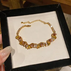 Close-up of French vintage gold bracelet with multicolored zircon stones in display box