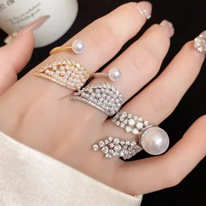 Detailed close-up shot of elegant pearl and zircon winged adjustable rings on hand