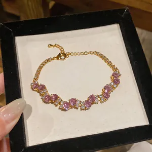 Close-up of a vintage gold bracelet with pink zircons and sparkling gems detail.