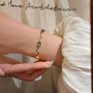 Elegant gold twisted bracelet featuring colorful geometric zircon gemstones on a wrist