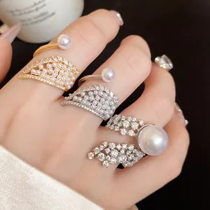 Detailed macro shot of elegant gold and silver zircon wing rings with lustrous pearls.