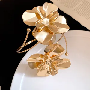 Vue détaillée d'un élégant bracelet de bras en métal doré aux motifs floraux texturés