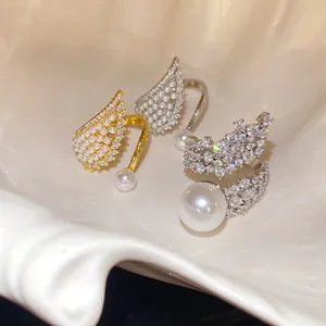 Elegant wing-shaped adjustable open rings adorned with pearls and sparkling cubic zirconia.