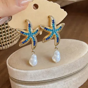 Detail shot of starfish earrings with blue rhinestones and baroque pearls