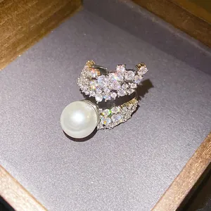 Detailed macro view of an elegant zircon wing open ring with a large lustrous white pearl
