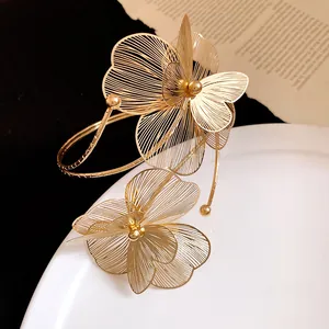 Détail d'un bracelet de bras en métal doré avec des motifs floraux en filigrane