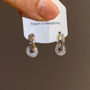 Macro view of elegant pave-set double ring hoop earrings shown on white display card