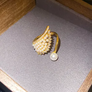 Elegant gold zircon wing open ring featuring delicate pearls in a luxury display box