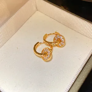 Detailed close-up shot of elegant gold pavé double hoop earrings in a jewelry box.