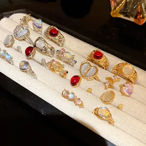 Variety of gold and silver tone rings with colorful resin stones in a display tray