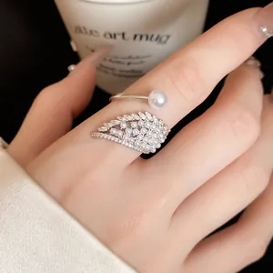 Macro shot of the intricate angel wing design featuring small pearls and sparkling zircons