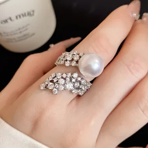 Close-up of elegant wing-shaped open ring with zircon and large pearl detail
