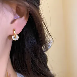 Exquisite gold-tone double-loop earrings with micro-paved rhinestones shown on ear