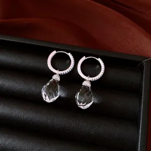 Elegant silver hoop earrings with sparkling crystal teardrop charms and tiny blue accents.